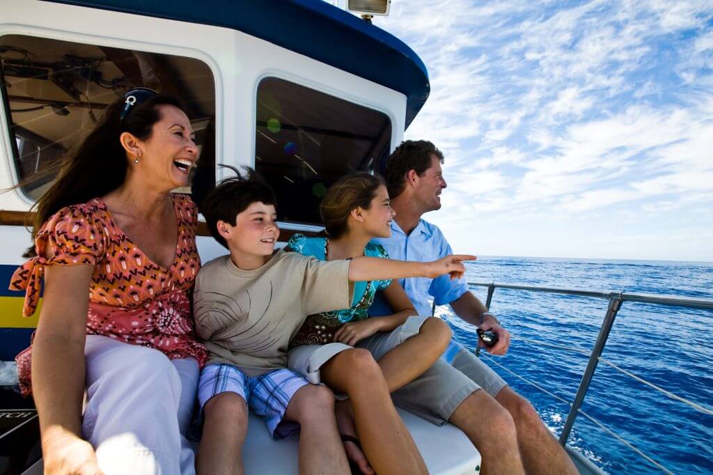 Create your ultimate Hawaii itinerary for your family. Image of a family with a boy and a girl enjoying a boat tour on Oahu.