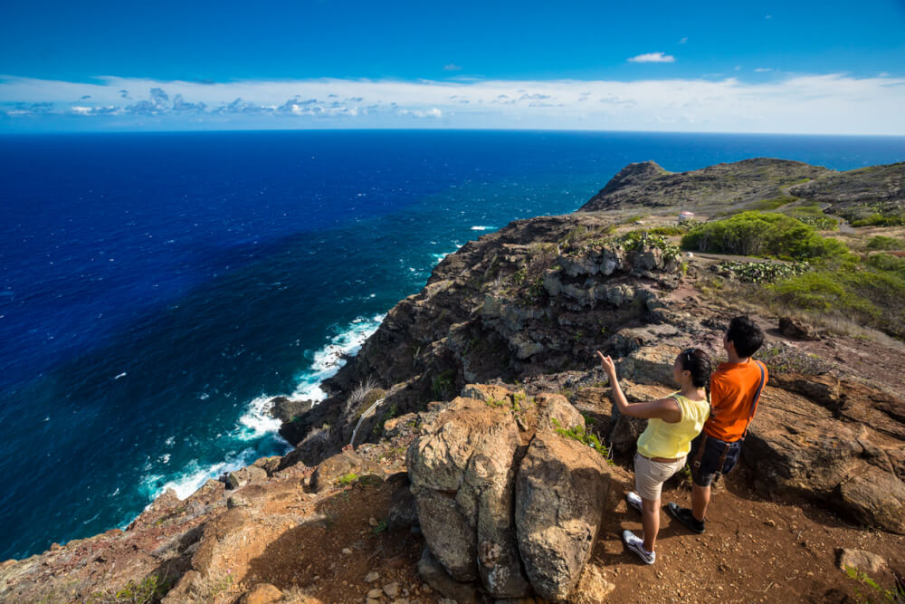 Oahu or Kauai: Which is the Best Hawaiian Island for Kids? Tips featured by top Hawaii travel blog, Hawaii Travel with Kids: Couple look across the Pacific from Makapuu Trail