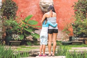 Things to Do in Hawaii with Kids: a review of Honolulu Museum of Art on Oahu featured by top Hawaii blog, Hawaii Travel with Kids: image of Girls hugging in the Asian Courtyard at the Honolulu Museum of Art on Oahu
