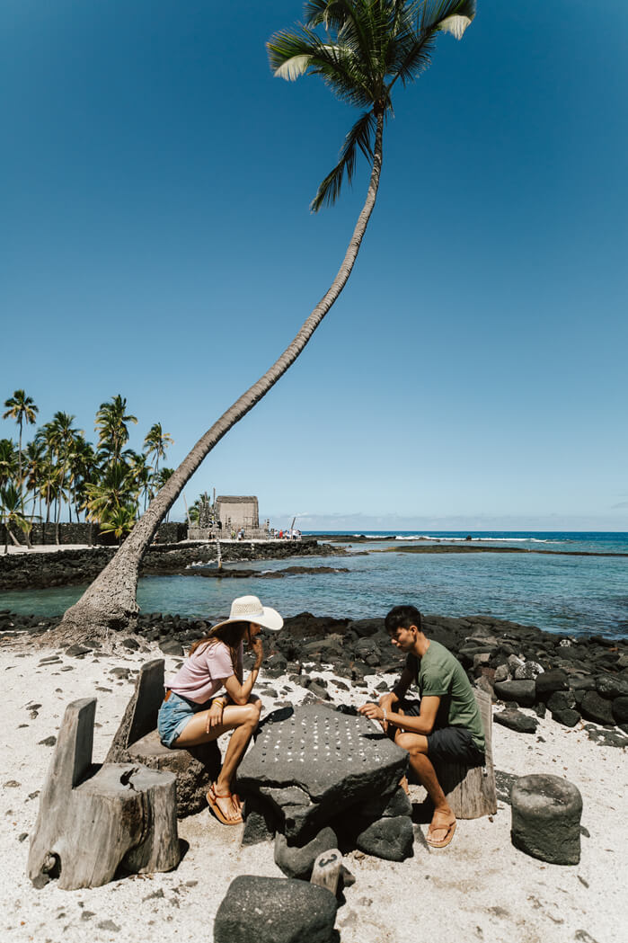 Where to Stay on the Big Island: Kona or Hilo, tips featured by top Hawaii blog, Hawaii Travel with Kids: Visitors play konane, a checkers-like game, at Puuhonua o Honaunau