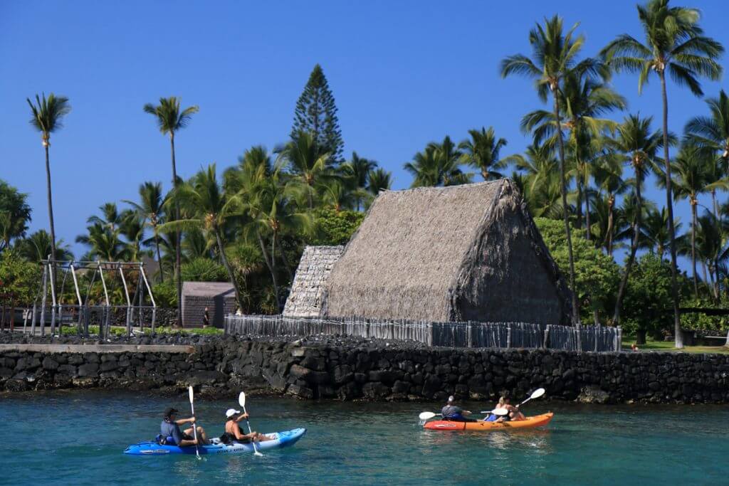 The Best Things to Do in Kona Hawaii featured by top Hawaii blog, Hawaii Travel with Kids: Kayakers cross Kamakahonu Bay near Ahuena Heiau, Historic Kailua Village