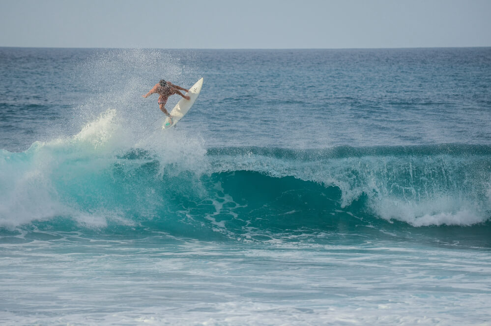 Surfer jumping a wave at Rocky Point on the North Shore of Oahu, Hawaii, USAOahu Surfing On The North Shore, a complete guide featured by top Hawaii blog, Hawaii Travel with Kids: 