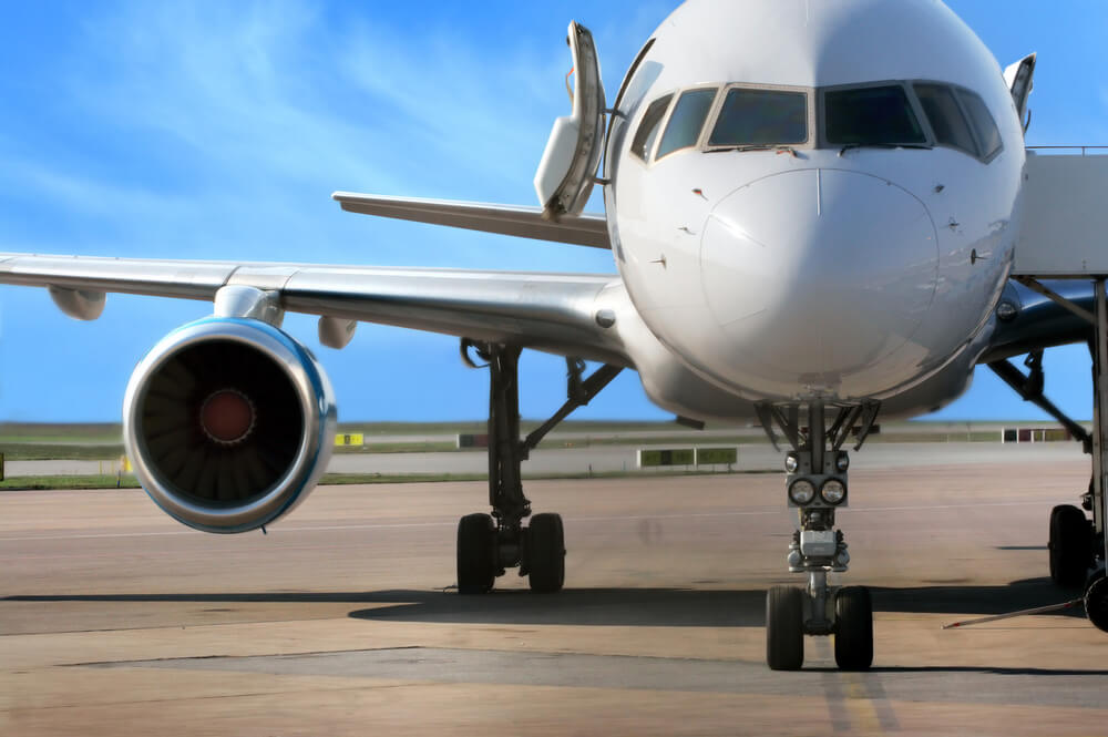 Wondering how far in advance you should buy airfare to Hawaii? The answer totally depends. Image of an airplane at the airport.