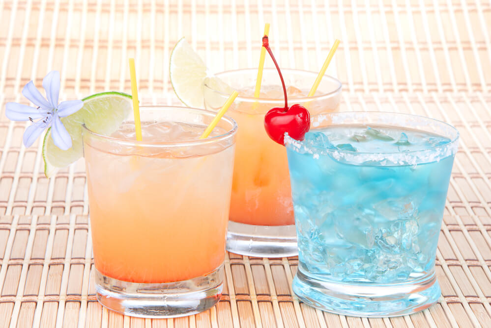 Wondering if there's restrictions on buying alcohol in Hawaii? You must be 21 years old. Image of Alcohol margarita cocktails, long island Iced tea, blue lagoon with lime and summer flower in short cocktail glasses isolated on a white background