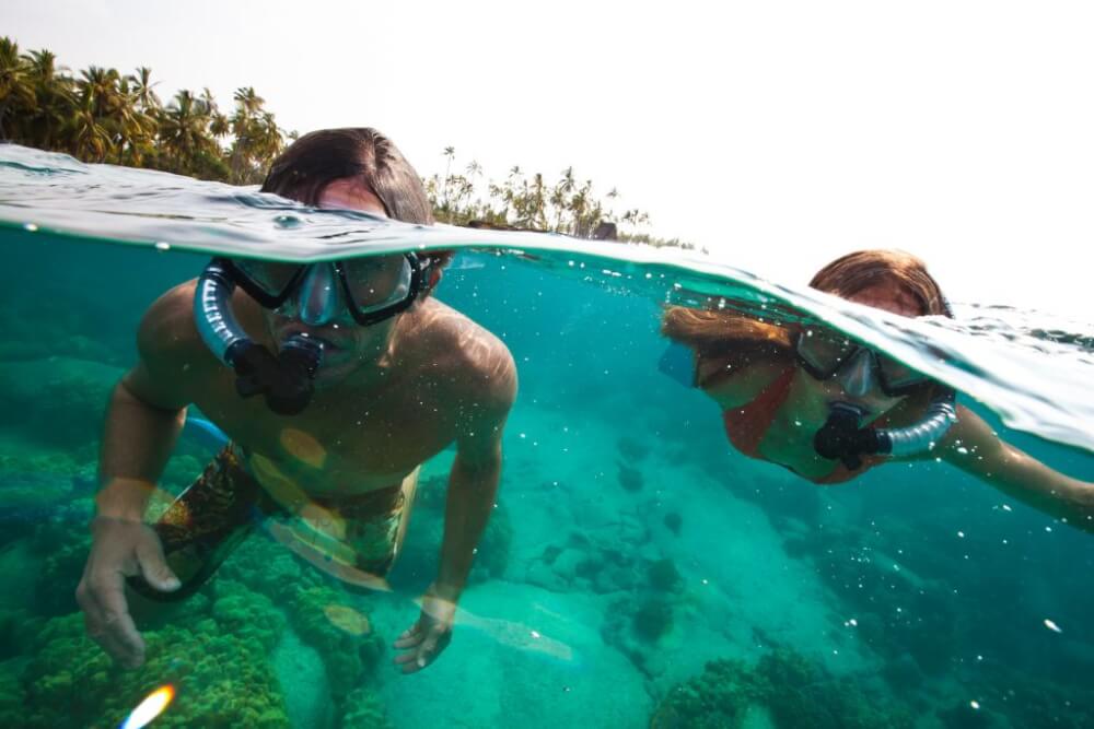 Find out where to snorkel on Kauai with kids. Image of kids snorkeling on Kauai.