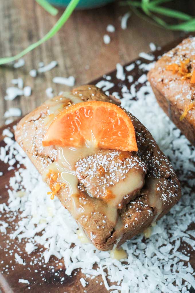 61 Delicious Coconut Dessert Recipes Perfect for Summer featured by top Hawaii blog, Hawaii Travel with Kids: Close up overhead view of an individual Coconut Clementine Mini Loaf Cake.