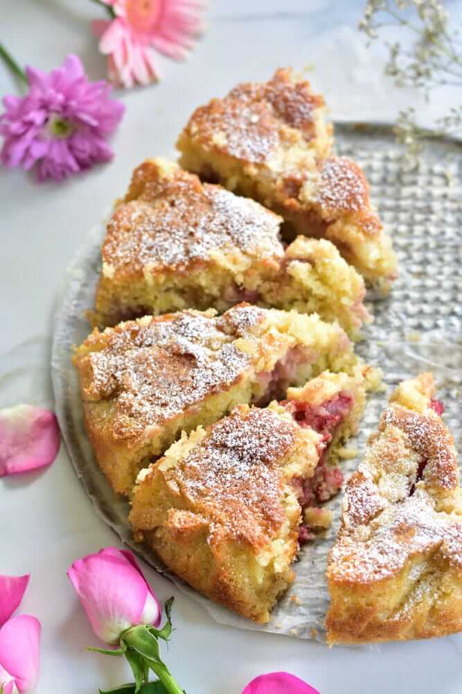 61 Delicious Coconut Dessert Recipes Perfect for Summer featured by top Hawaii blog, Hawaii Travel with Kids: Strawberry coconut cake cut into servings, flowers scattered around