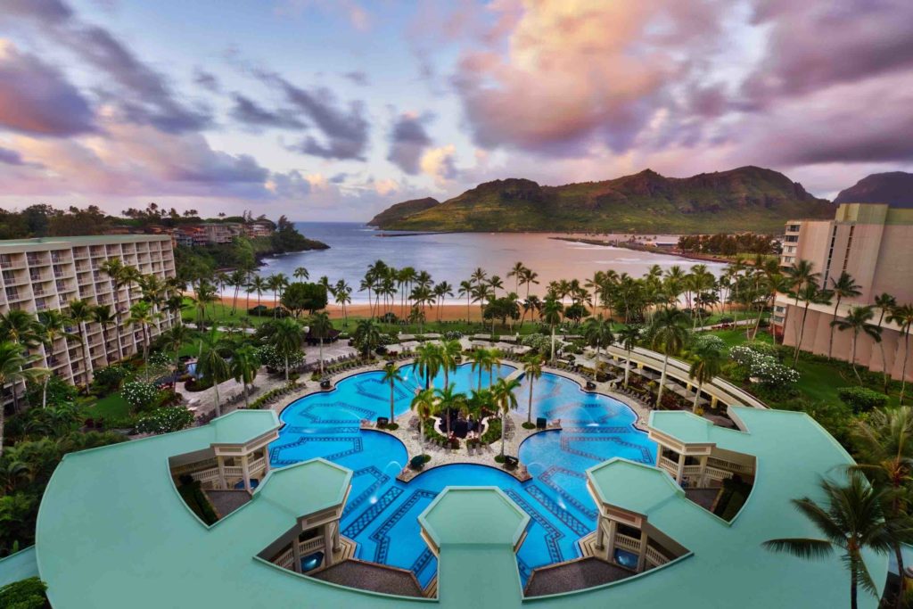 One of the best places to stay for a Kauai babymoon is the Royal Sonesta Kauai. Image of a large pool on the beach.
