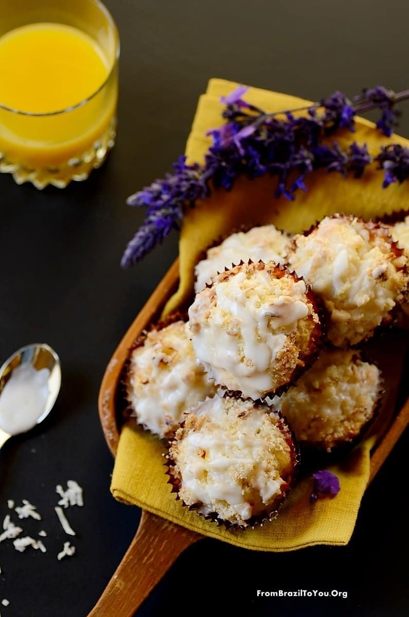 61 Delicious Coconut Dessert Recipes Perfect for Summer featured by top Hawaii blog, Hawaii Travel with Kids: Serving Mango Coconut Streusel Muffins in a platter with flowers on the side and a glass of juice