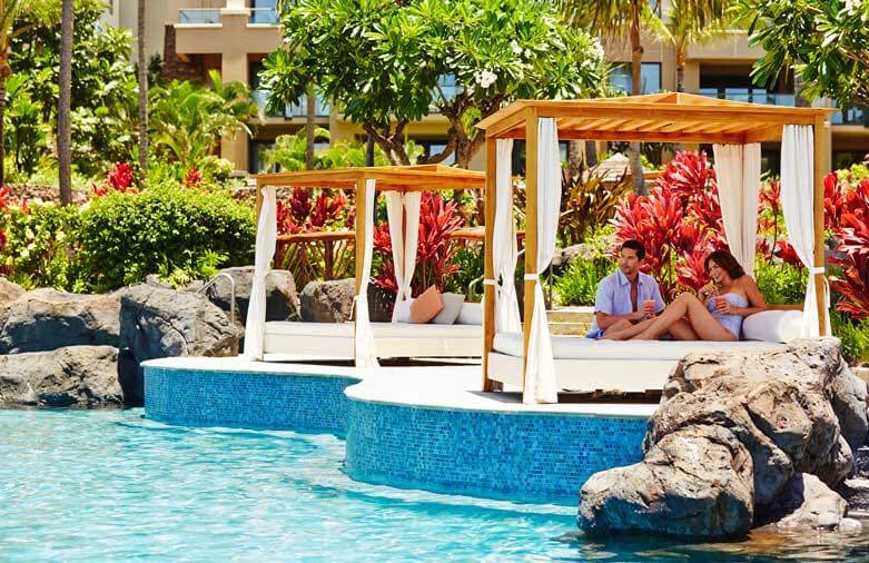 Image of a couple sitting in a private cabana by the pool at Montage Kapalua Bay on Maui.