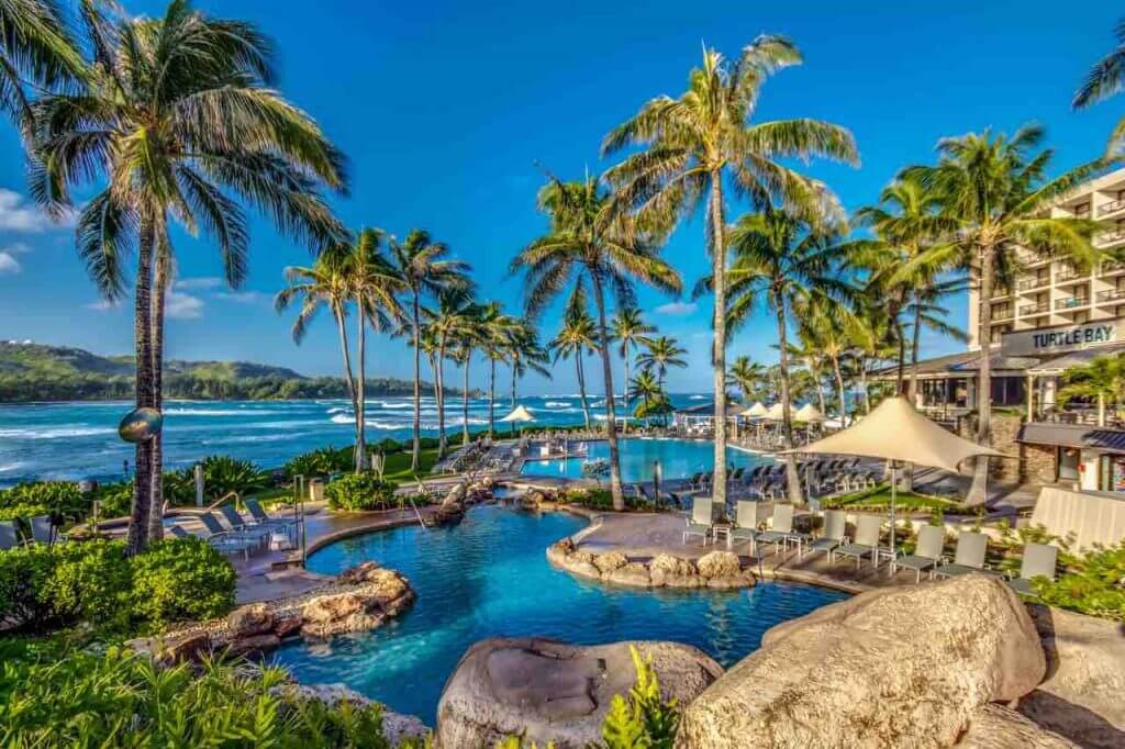 Turtle Bay Resort is a top North Shore Oahu hotel. Image of a tropical pool area by the ocean.