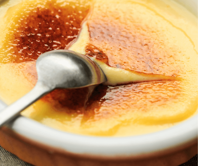 61 Delicious Coconut Dessert Recipes Perfect for Summer featured by top Hawaii blog, Hawaii Travel with Kids: Closeup Photo of sugar breaking on top of Coconut Crème Brûlée