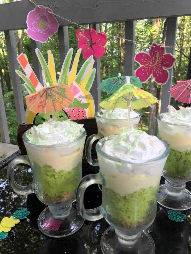 61 Delicious Coconut Dessert Recipes Perfect for Summer featured by top Hawaii blog, Hawaii Travel with Kids: Close up key lime coconut parfaits with luau flowers and decorations