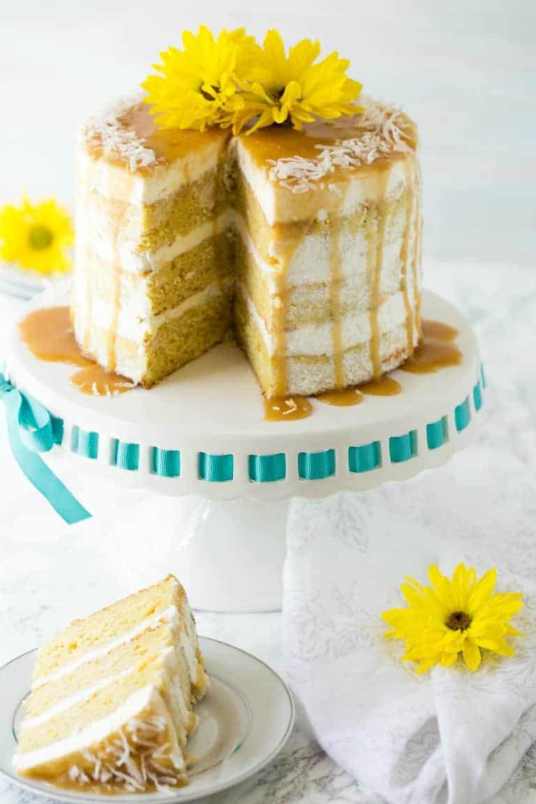 61 Delicious Coconut Dessert Recipes Perfect for Summer featured by top Hawaii blog, Hawaii Travel with Kids: mango cake on a cake stand with slice removed