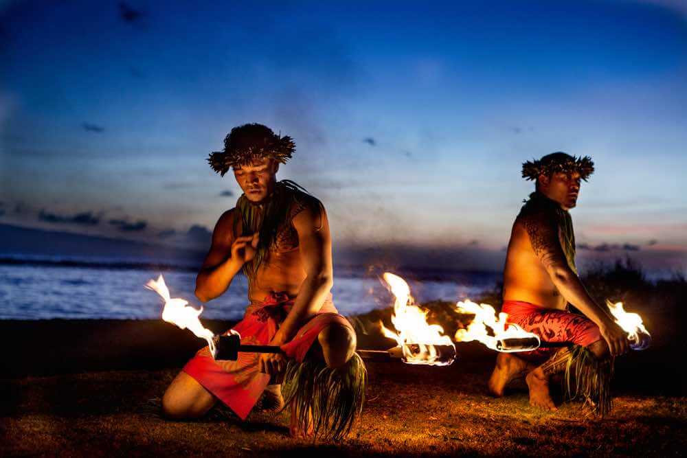 Due uomini hawaiani che si preparano a ballare con il Fuoco a Maui