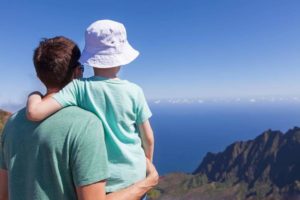 101 Best Things to Do on Kauai with Kids featured by top Hawaii blog, Hawaii Travel with Kids: family of father and son enjoying kalalau valley together at kauai island, hawaii