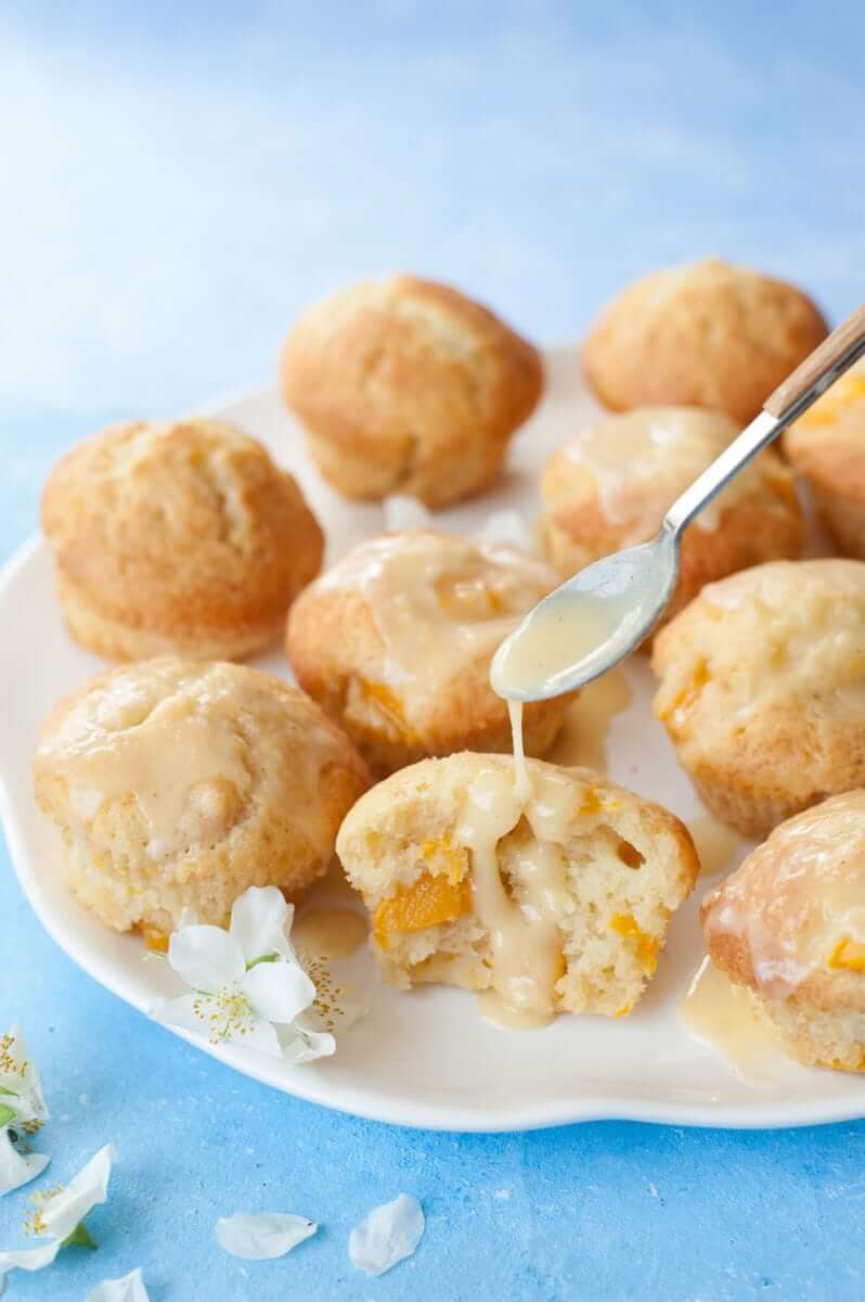 Best Mango dessert recipes by top Hawaii blog Hawaii Travel with Kids: passion fruit glaze is being drizzled over mango muffins