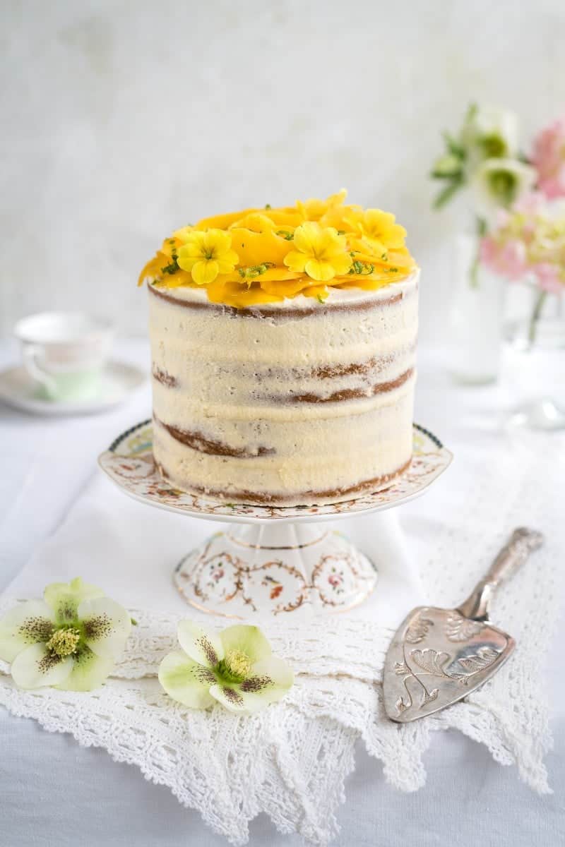 Best Mango dessert recipes by top Hawaii blog Hawaii Travel with Kids: Tall vegan layer cake topped with a mango rose and edible flowers