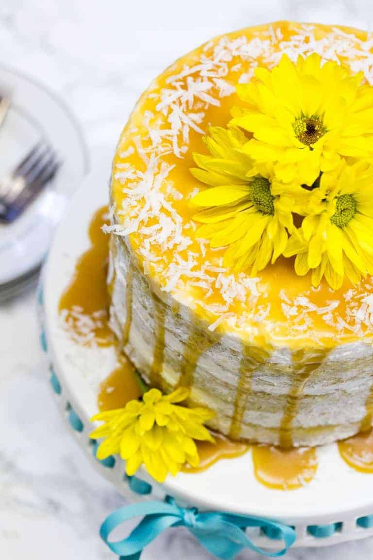 Best Mango dessert recipes by top Hawaii blog Hawaii Travel with Kids: overhead view of mango cake on a cake pan with yellow flowers on top