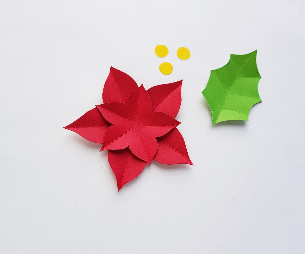 How to Make a Paper Poinsettia Craft, a tutorial featured by top Hawaii blog, Hawaii Travel with Kids: Image of pieces of paper cut out and partially assembled to form a poinsettia