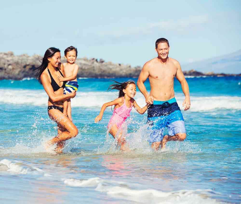 Planning a Hawaii tripi? Don't go for just the weekend. Image of Young Happy Family Playing Having Fun at the Beach Outdoors