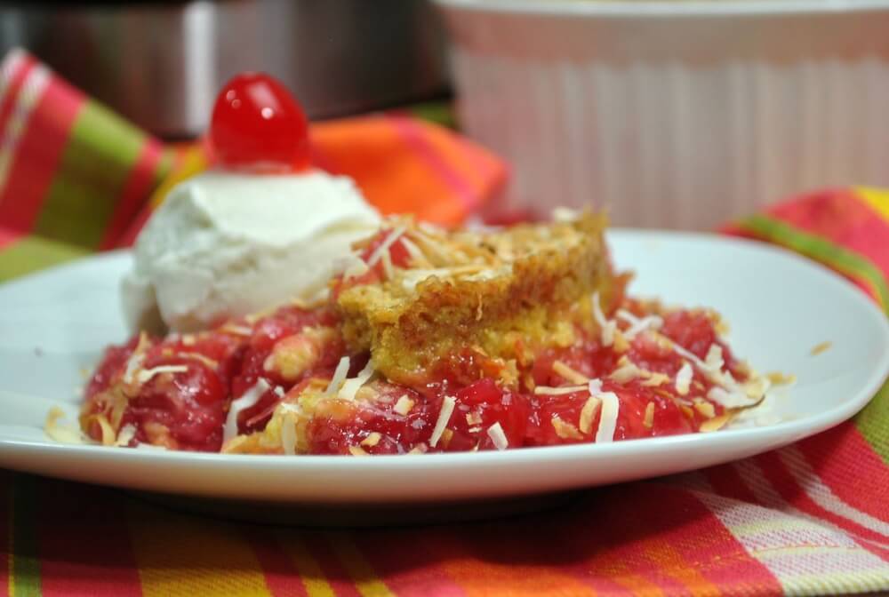 Learn how to make this easy Instant Pot Pina Colada Dump Cake by top Hawaii blog Hawaii Travel with Kids. Image of a pineapple coconut cake with ice cream and a cherry on top.