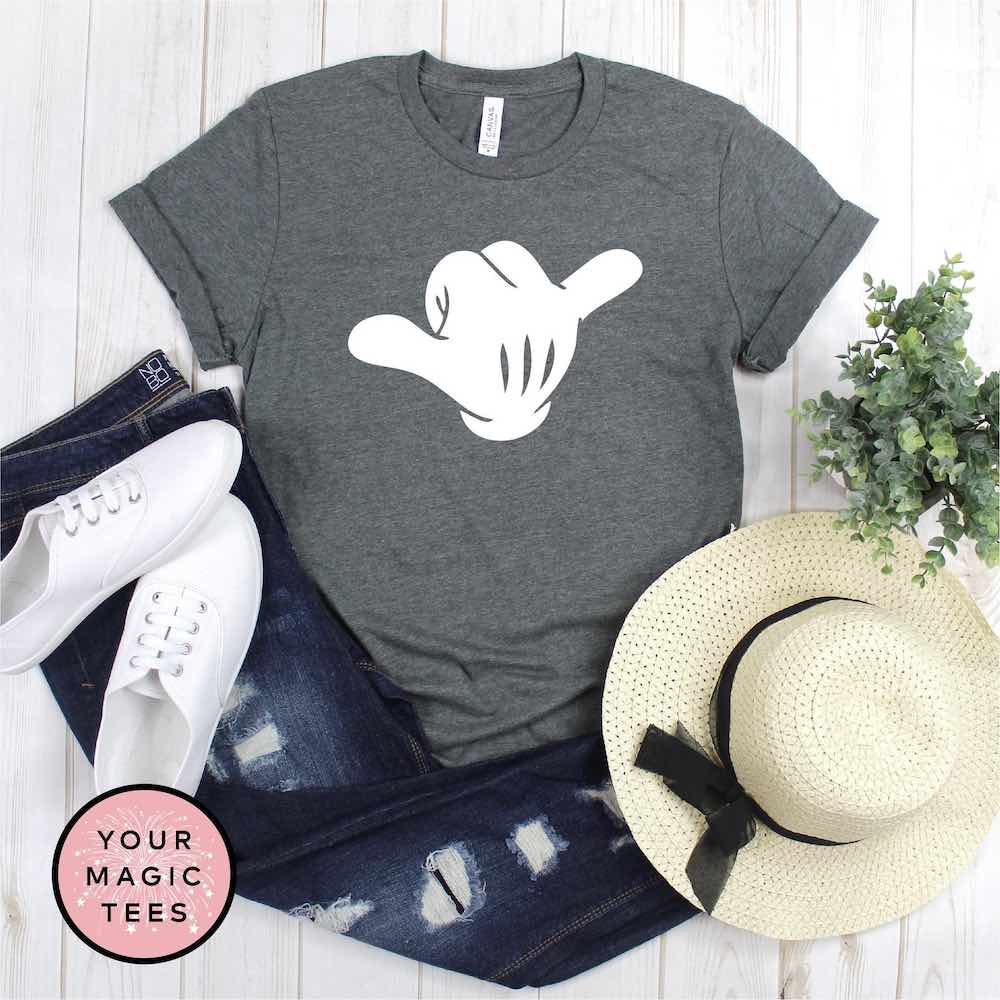 Find out the cutest Disney Aulani t-shirts to buy before your trip to Disney's Aulani Resort in Hawaii by top Hawaii blog Hawaii Travel with Kids. Buy this adorable shaka Disney shirt for your next trip to Aulani Resort. Image of a Mickey hand throwing a shaka sign.