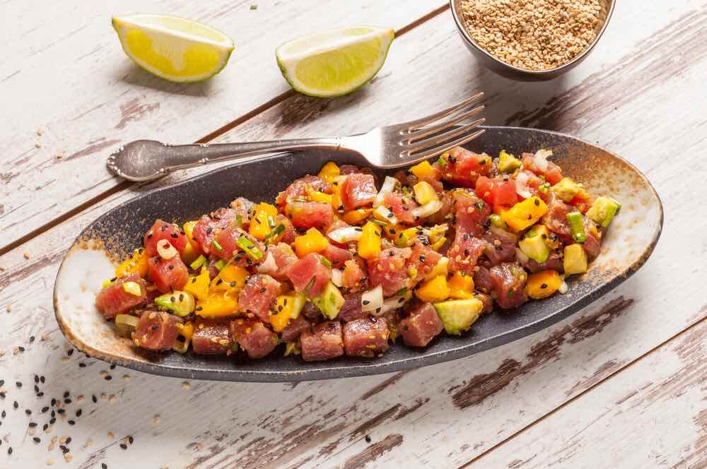 Find out the best places to eat in Waikiki. Image of: Hawaiian tuna poke with mango, avocado, onion and sesame seeds.
