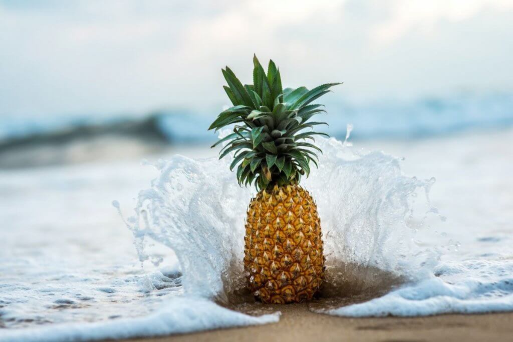 Find out whether you should use fresh or canned pineapple upside down rum cake. Image of a pineapple on the beach with waves crashing into it.