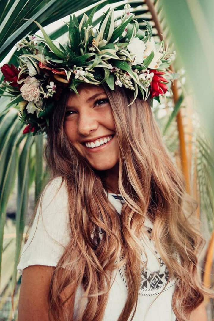 Making a flower lei crown is one of the most fun things to do on Oahu. Image of a woman wearing a lei po'o.