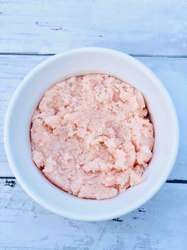 Learn how to make this recipe for sea salt scrub by top Hawaii blog Hawaii Travel with Kids. Image of a bowl of pink sea salt scrub.