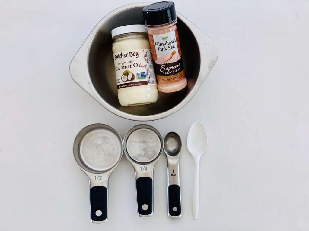 These are the DIY coconut oil body scrub ingredients and tools. Image of measuring cups, oconut oil and pink Himalayan sea salt.