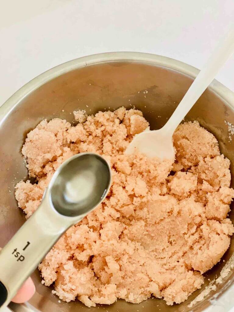 Add a bit of water to this DIY sea salt scrub to get the right consistency. Image of someone finishing up a coconut oil body scrub DIY.