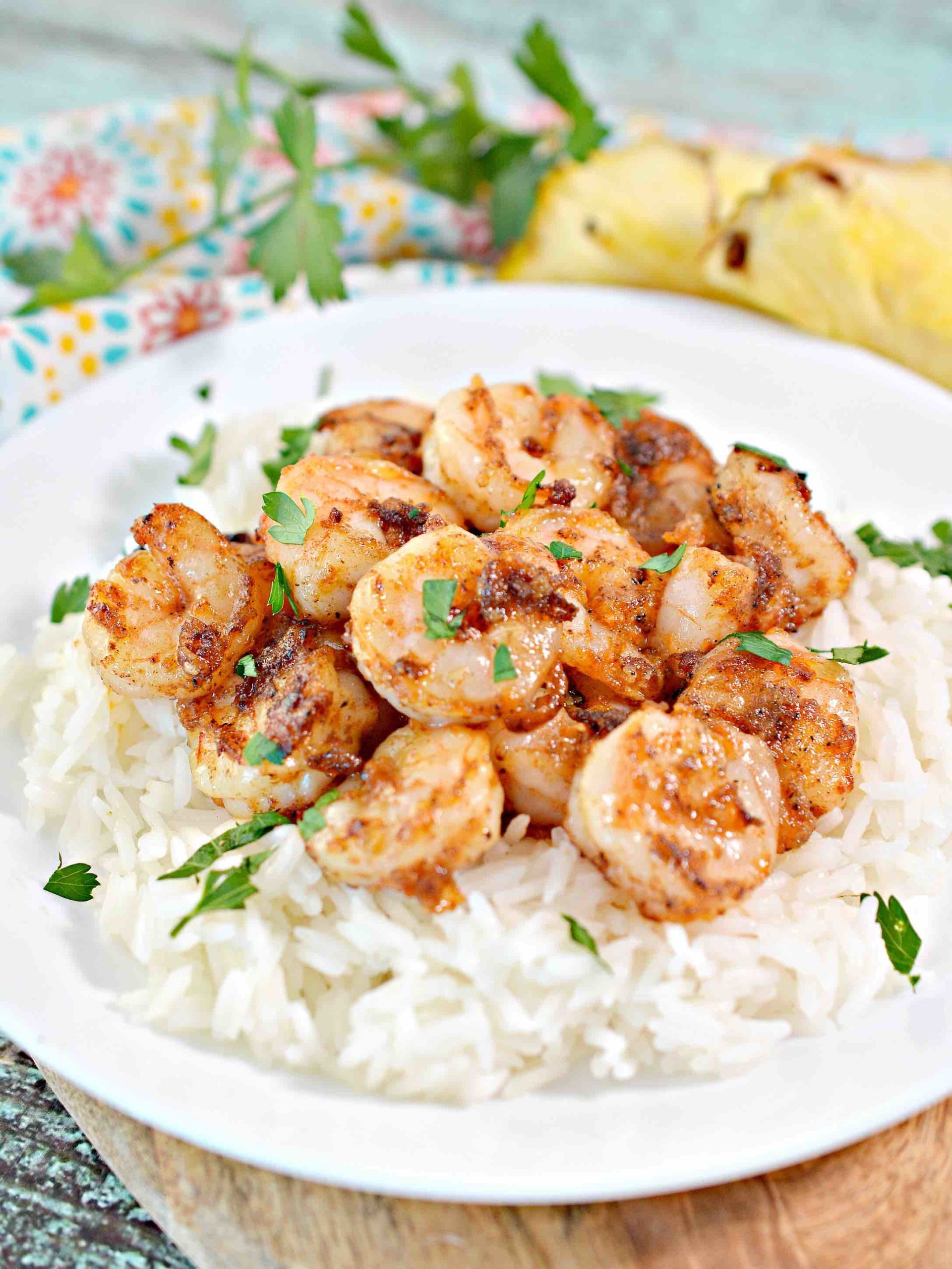 Learn how to make Hawaiian Garlic Shrimp by top Hawaii blog Hawaii Travel with Kids. Image of a plate of rice topped with Hawaiian shrimp.