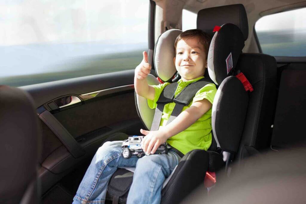 Image of a toddler in a car seat in a Hawaii rental car.