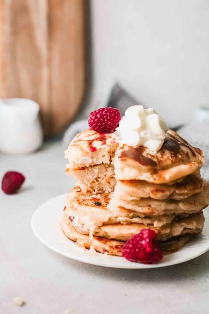 This is seriously the best mochi pancake recipe! Image of a stack of mochi pancakes on a plate with a big bite taken out.