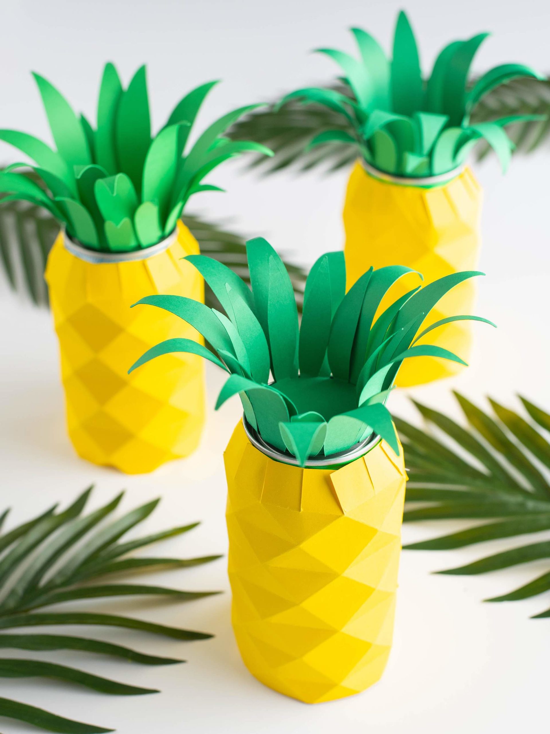 Learn how to make a pineapple centerpiece by top Hawaii blog Hawaii Travel with Kids. Image of 3 paper luau centerpieces.