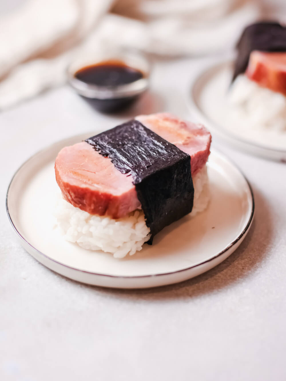 Learn how to make Spam Musubi by top Hawaii blog Hawaii Travel with Kids. Image of a plate of Spam sushi.
