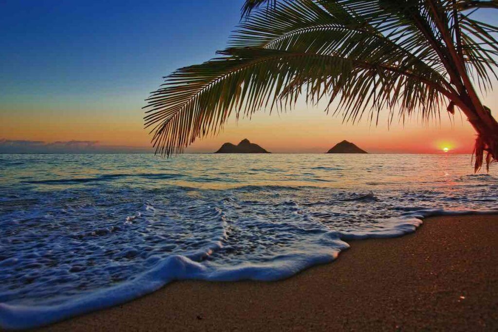 One of the best free things to do in Oahu on your first morning is to see an Oahu sunrise. Image of sunrise at Lanikai beach on Oahu.