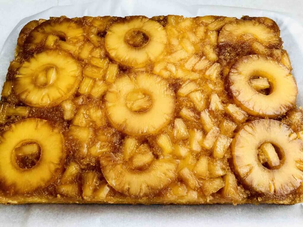 Image of a fully cooked pineapple upside down cake that has been flipped onto a heat-safe surface.