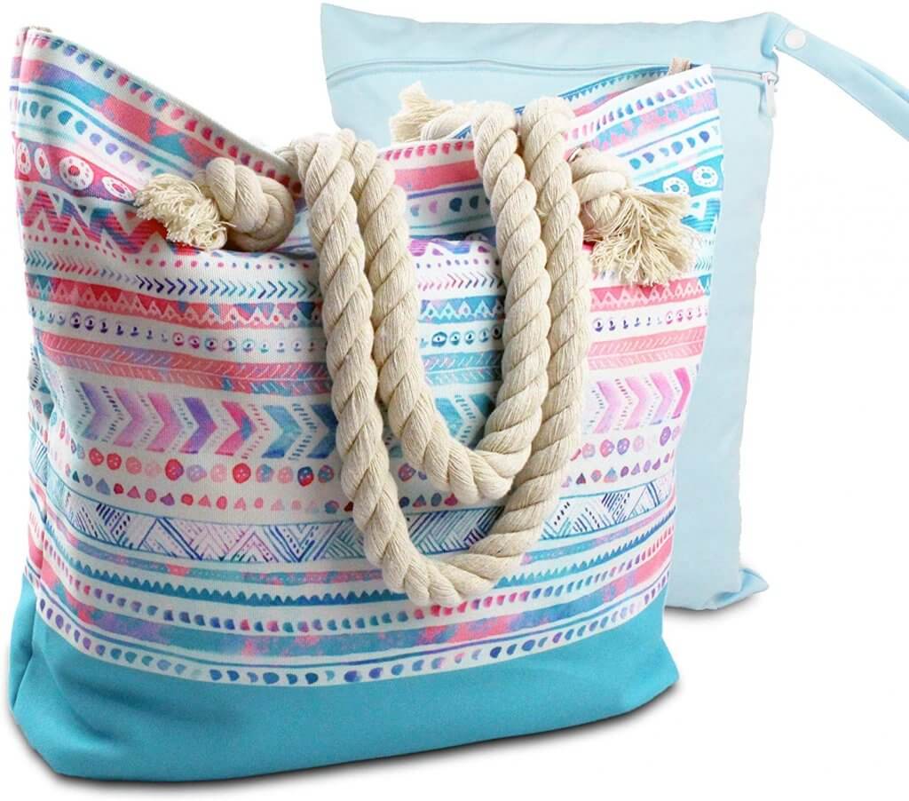 This Boho beach bag is water resistant and comes with a bonus wet/dry bag. Image of a pink and blue beach bag with rope handles.