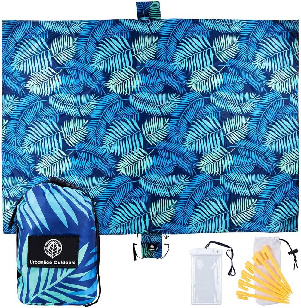 A sandfree beach blanket is a top beach must haves for baby. Image of a blue tropical leaf print towel.