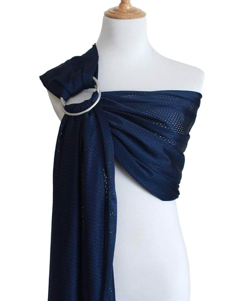 A water ring sling is what to take to the beach with a baby if you plan on going into the ocean. Image of a navy blue mesh ring sling for babies.