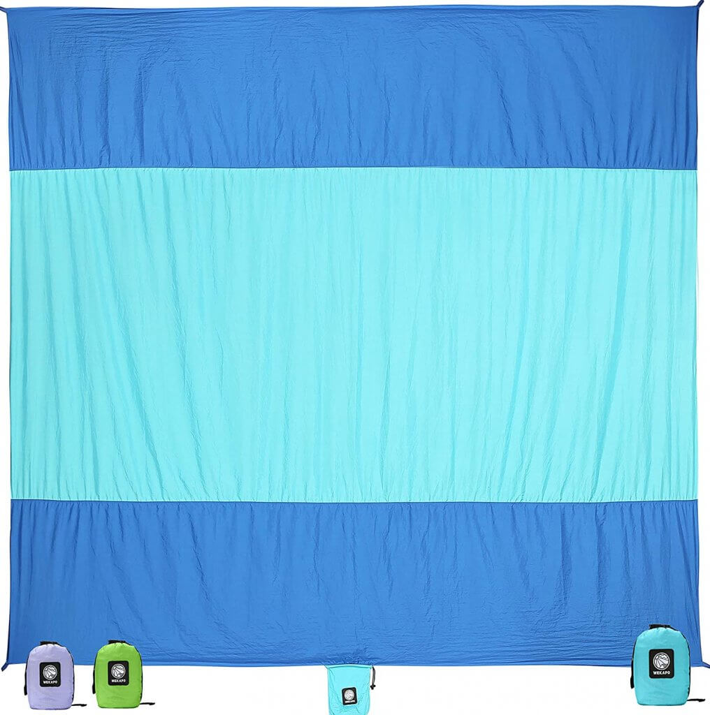 A sand free beach towel is one of the best beach essentials for baby. Image of a blue and teal striped beach towel.