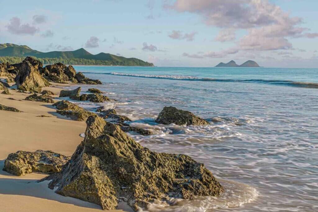 Bellows Beach is one of the best beaches on Oahu for a military vacation to Hawaii. Image of Rock outcropping at the shore of Bellows Beach at dawn on Waimanalo Bay on Oahu, Hawaii.