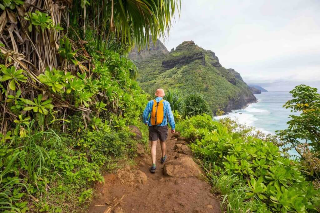 Image of a man hiking along the Na Pali coast on Kauai.