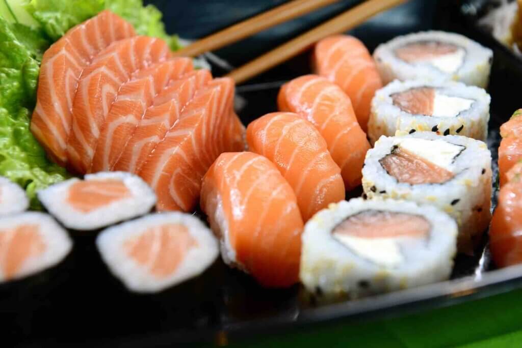 Find out where to get the best sushi in Maui Hawaii by top Hawaii blog Hawaii Travel with Kids. Image of a plate of salmon sashimi, nigiri, and sushi rolls.