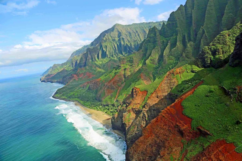 Exploring the Na Pali Coast is just one of the many best things to do on Kauai on a budget recommended by top Hawaii blog Hawaii Travel with Kids. Image of a rugged coastline.