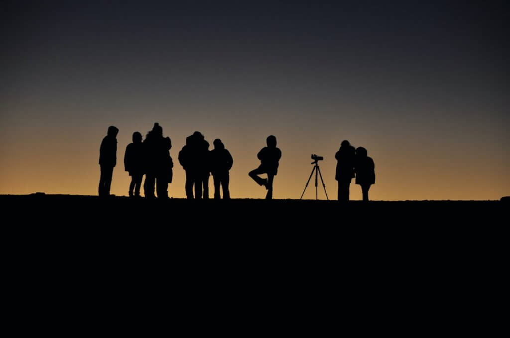 Stargazing at Haleakala is a top thing to do on Maui. Image of the silhouette of a group of stargazers at Haleakala National Park.