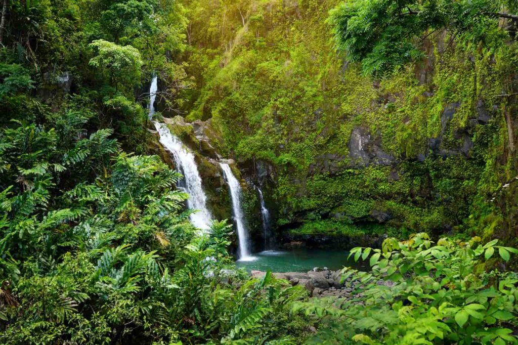 Upper Waikani Falls also known as Three Bears, a trio of large waterfalls amid rocks & lush vegetation with a popular swimming hole, off the Road to Hana Highway, Maui, Hawaii, USA